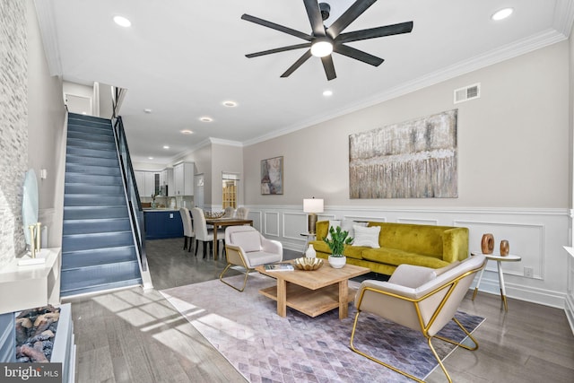 living room with hardwood / wood-style floors, ceiling fan, and crown molding