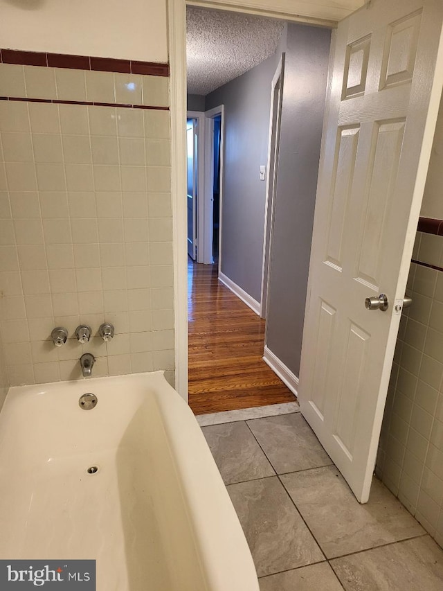 bathroom with hardwood / wood-style floors and a textured ceiling