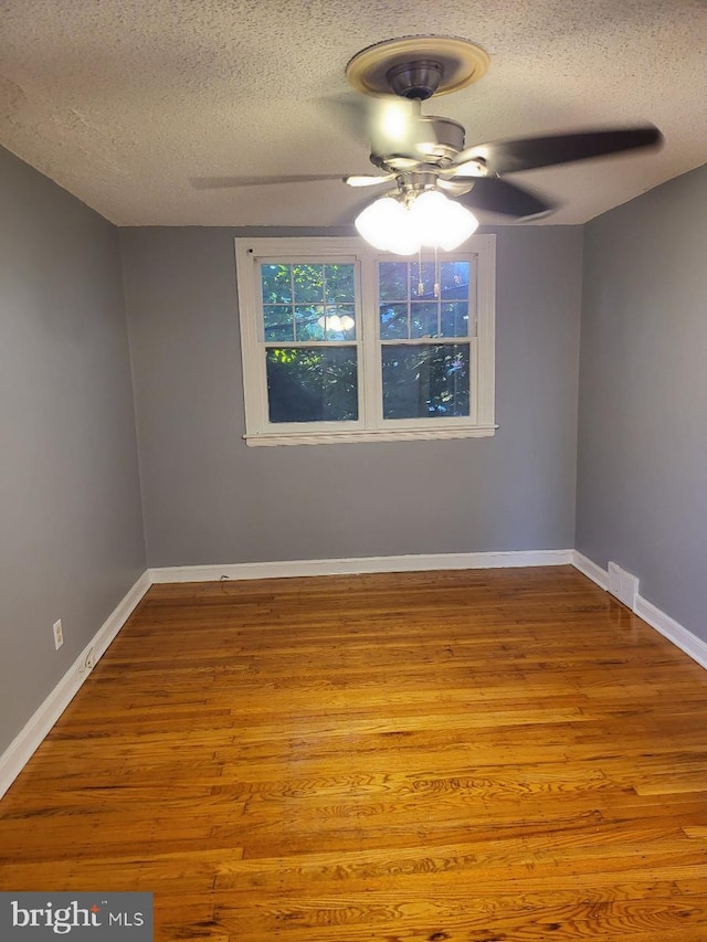 unfurnished room featuring ceiling fan, a textured ceiling, and light wood-type flooring