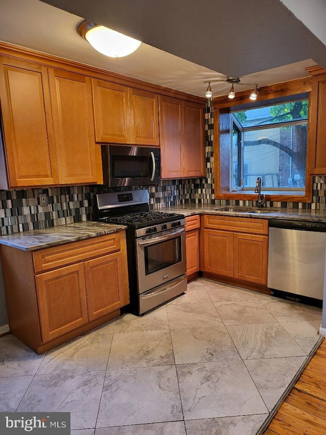 kitchen with decorative backsplash, stainless steel appliances, and sink