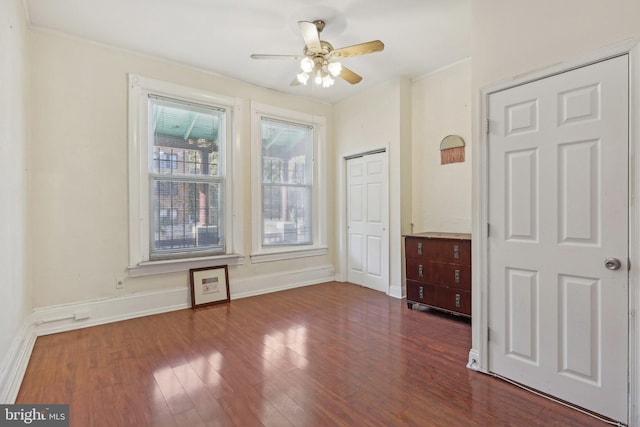 unfurnished room featuring ceiling fan, ornamental molding, and dark hardwood / wood-style floors