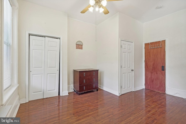 unfurnished bedroom featuring multiple windows, dark hardwood / wood-style floors, and ceiling fan