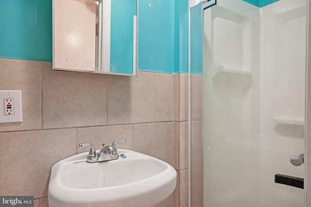 bathroom featuring tile walls and sink