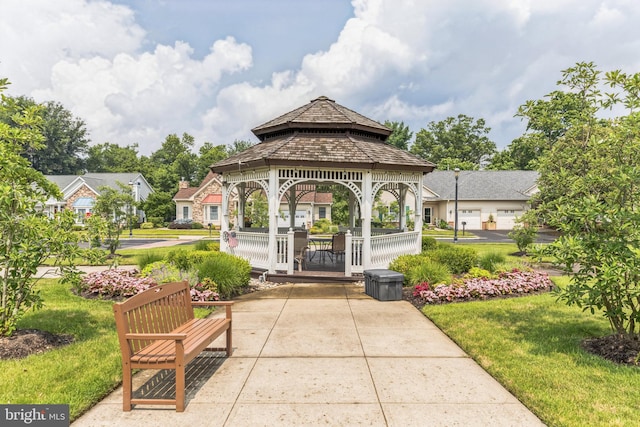 view of community with a yard, a gazebo, and a garage