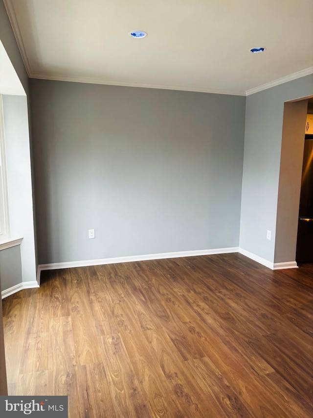 spare room featuring hardwood / wood-style floors and ornamental molding