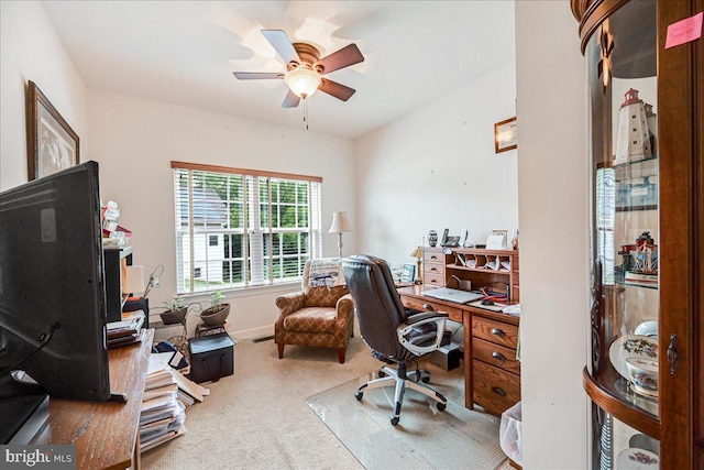 carpeted office space featuring ceiling fan