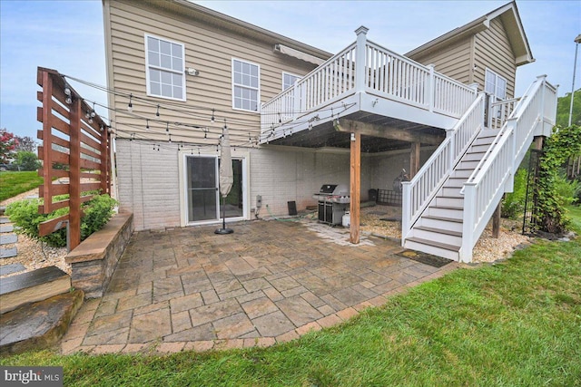 rear view of property with a wooden deck, a yard, and a patio area