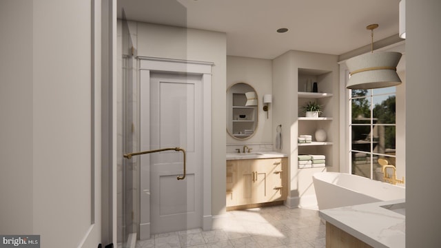 bathroom featuring built in shelves, vanity, and a bathtub