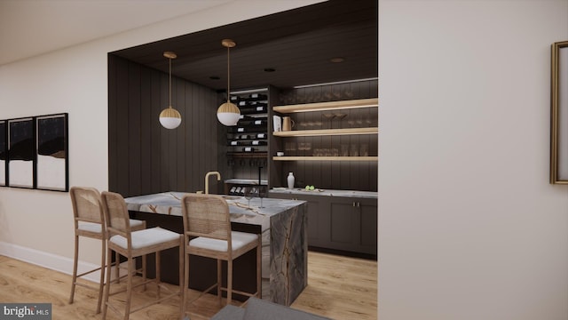 bar featuring hanging light fixtures and light hardwood / wood-style floors