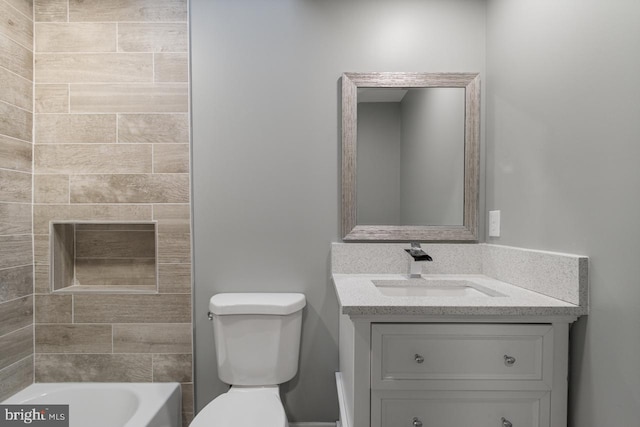 bathroom with vanity, a bathtub, and toilet