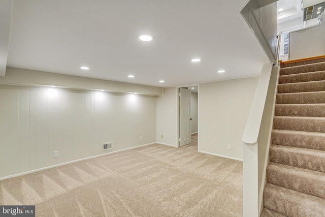 basement featuring light carpet