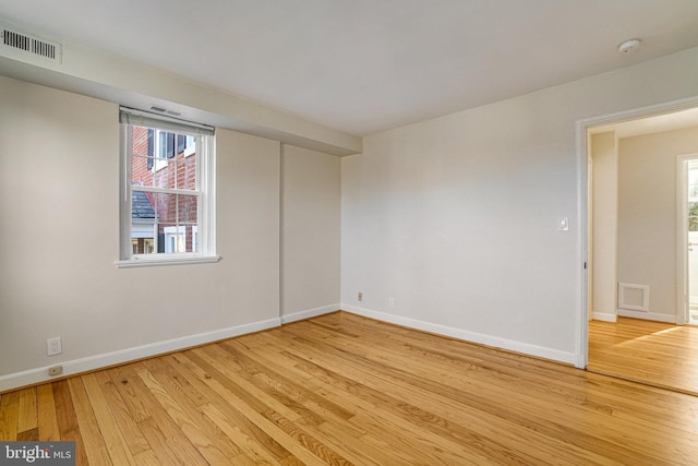 spare room with a wealth of natural light and light hardwood / wood-style floors