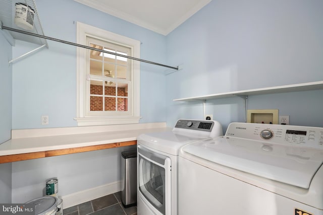 clothes washing area with crown molding, washing machine and clothes dryer, and dark tile patterned flooring