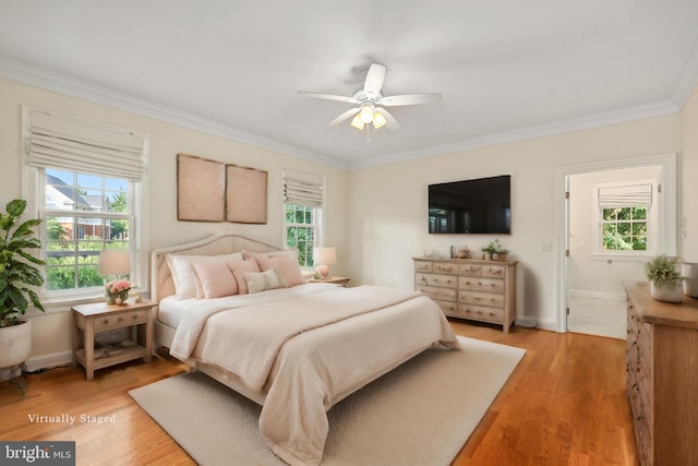 bedroom featuring hardwood / wood-style floors, crown molding, and ceiling fan