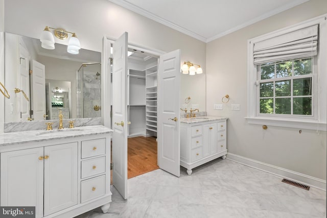 bathroom featuring vanity, a shower with shower door, and ornamental molding