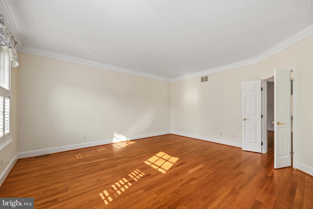 empty room featuring crown molding and wood-type flooring