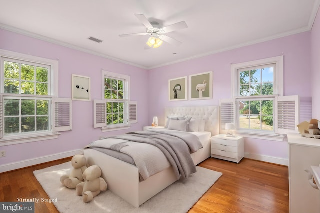 bedroom with hardwood / wood-style flooring, multiple windows, and ceiling fan