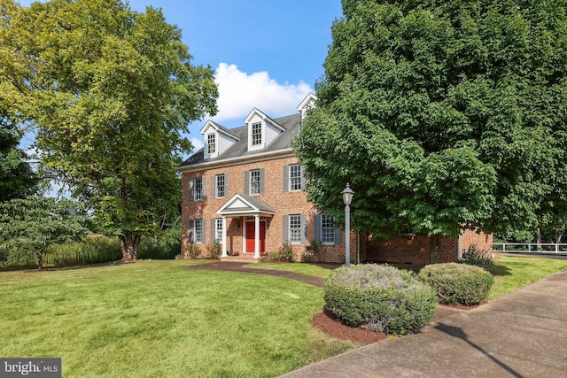 colonial inspired home featuring a front lawn