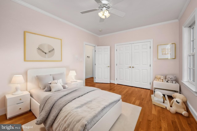 bedroom with ornamental molding, hardwood / wood-style floors, a closet, and ceiling fan