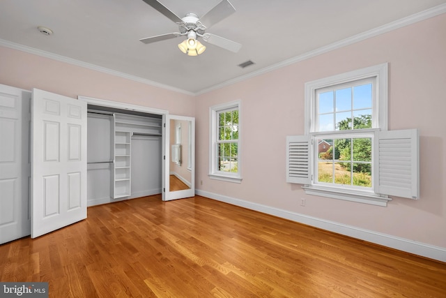 unfurnished bedroom with light hardwood / wood-style floors, crown molding, and multiple windows