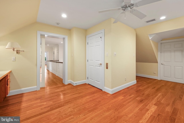 additional living space with light hardwood / wood-style floors, vaulted ceiling, and ceiling fan