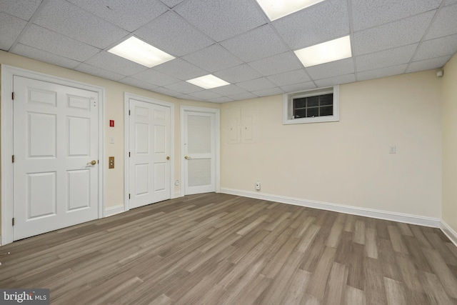 interior space featuring a paneled ceiling and wood-type flooring