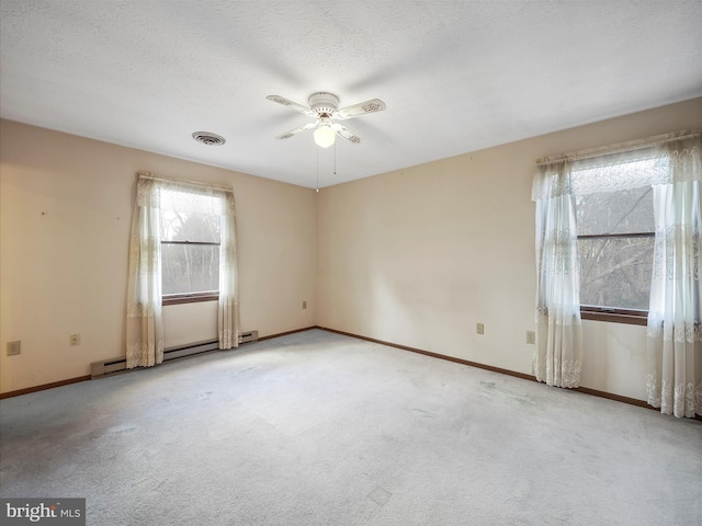 carpeted empty room featuring ceiling fan, a baseboard radiator, and a textured ceiling