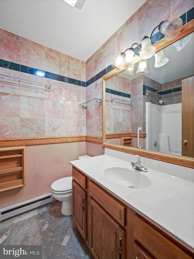 bathroom with vanity, a baseboard heating unit, toilet, and a textured ceiling