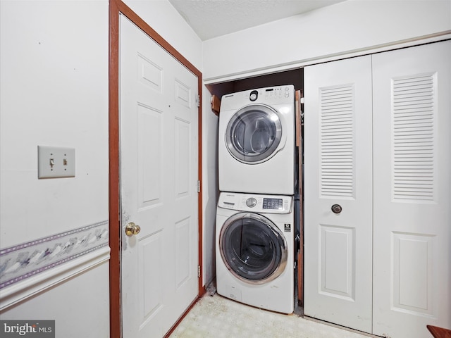 washroom featuring stacked washer and clothes dryer