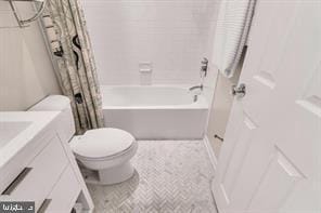 bathroom with shower / bath combination with curtain, toilet, and vanity