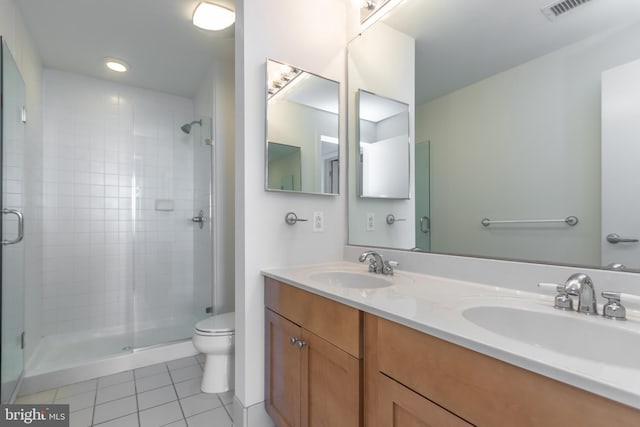 bathroom featuring vanity, toilet, walk in shower, and tile patterned flooring