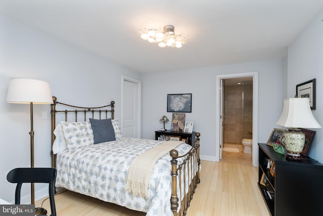 bedroom with ensuite bathroom and light wood-type flooring