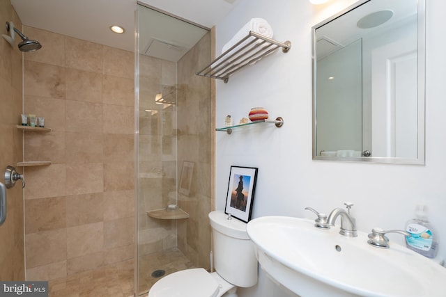 bathroom featuring toilet, sink, and an enclosed shower