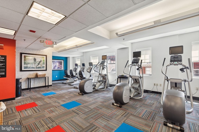 workout area featuring a drop ceiling and dark colored carpet