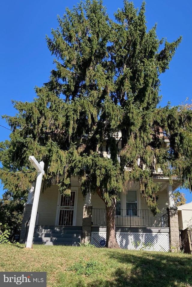 view of front of property featuring covered porch and a front yard