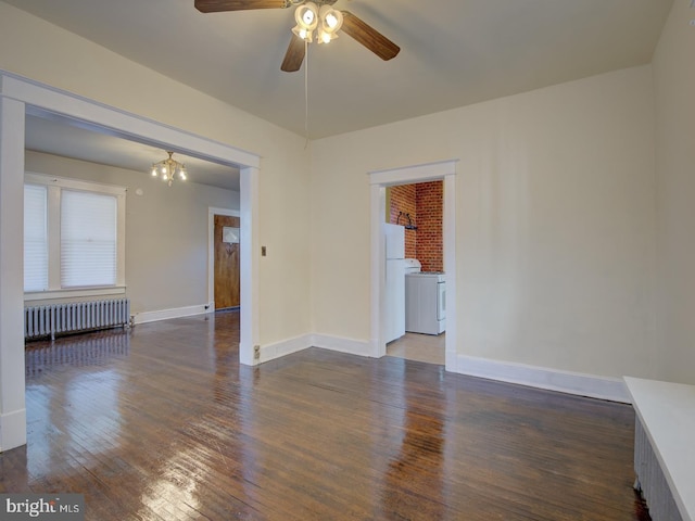 empty room with dark wood-type flooring, radiator, washer / clothes dryer, and ceiling fan with notable chandelier