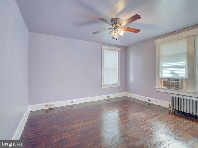 spare room featuring radiator, ceiling fan, cooling unit, and dark hardwood / wood-style flooring