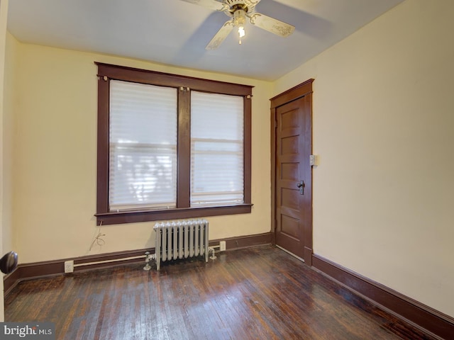 spare room featuring radiator heating unit, ceiling fan, and dark hardwood / wood-style flooring