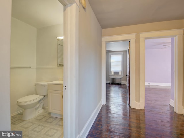 corridor featuring wood-type flooring and radiator heating unit