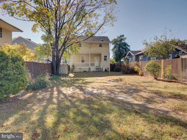 back of house featuring a porch and a lawn