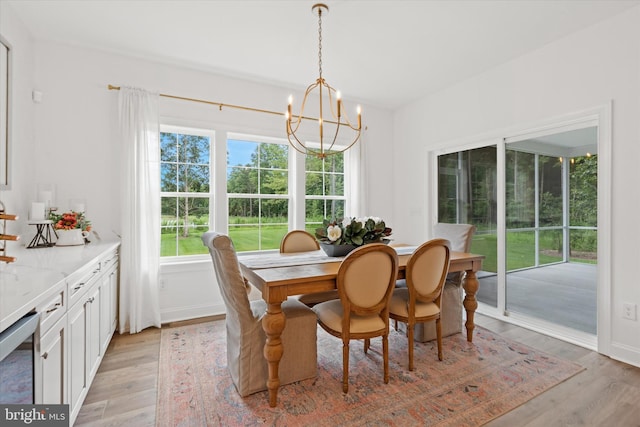 dining area featuring an inviting chandelier, light hardwood / wood-style flooring, and beverage cooler