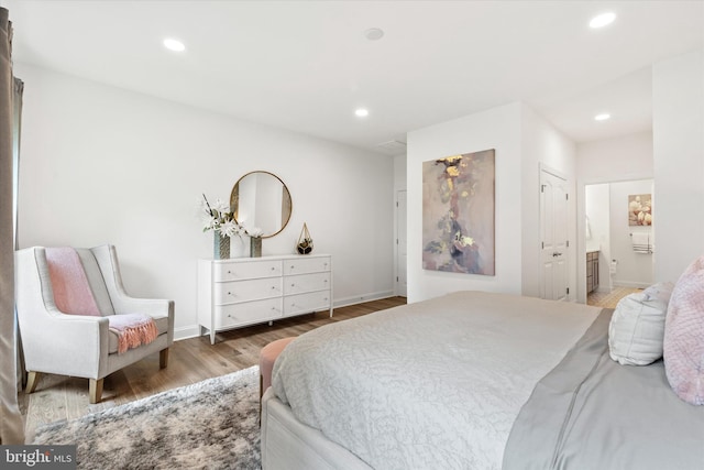 bedroom featuring ensuite bathroom and wood-type flooring