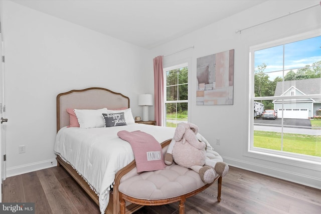 bedroom featuring multiple windows and dark hardwood / wood-style floors