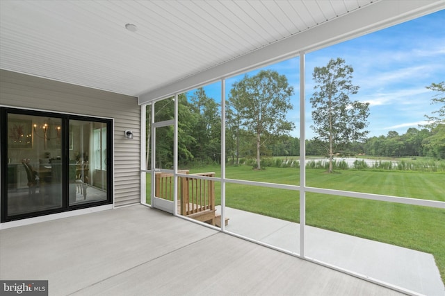 unfurnished sunroom with a water view