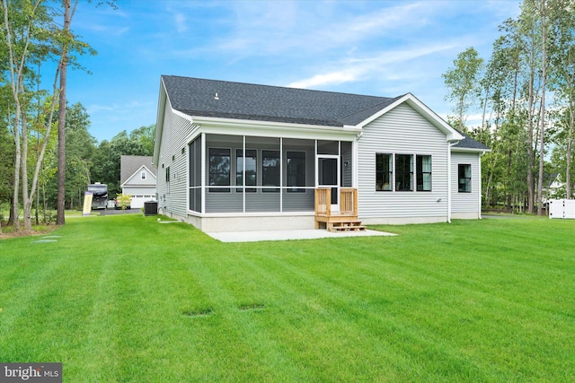 back of property featuring a sunroom, a lawn, and central AC unit