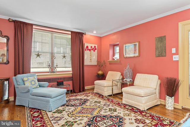 sitting room with crown molding, wood-type flooring, and radiator