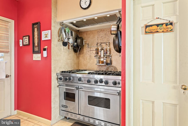 kitchen featuring extractor fan, backsplash, range with two ovens, and light tile patterned floors