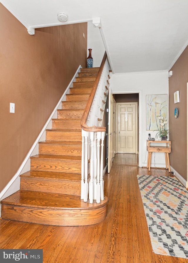 stairway featuring crown molding and hardwood / wood-style floors