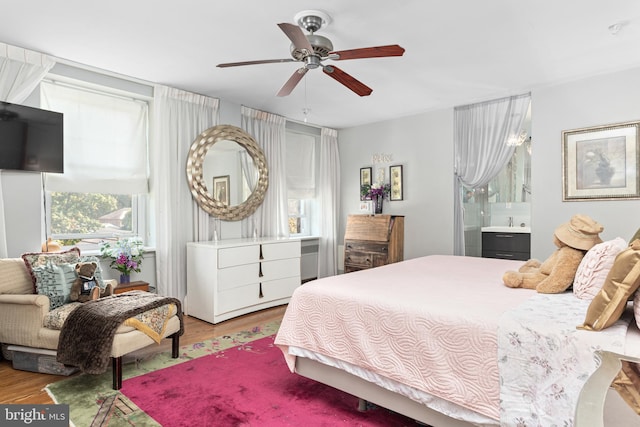 bedroom featuring ensuite bath, sink, light hardwood / wood-style flooring, and ceiling fan