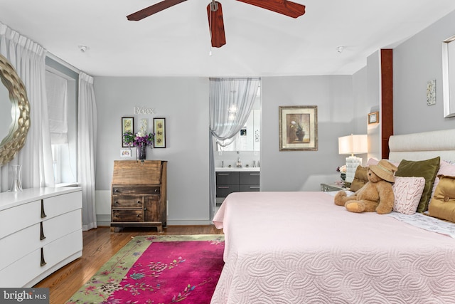 bedroom with hardwood / wood-style flooring, ensuite bath, and ceiling fan